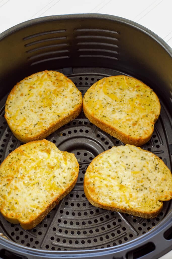 Four pieces of New York Bakery Texas Toast in the air fryer basket after being air fried.