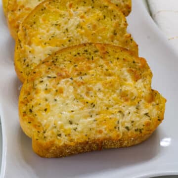 Slices of texas toast that has been air fried on a white plate
