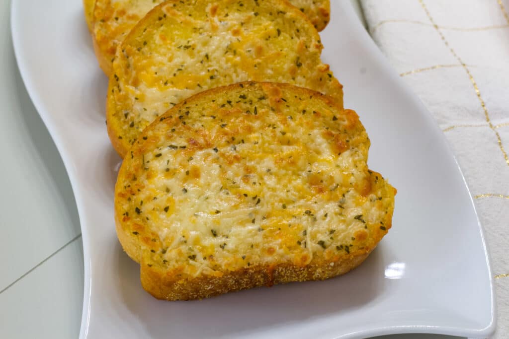 Several pieces of air fried Texas Toast on a white plate.