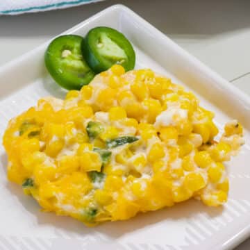 One serving of Easy Jalapeno Cream Cheese Corn Casserole on a plate with two slices of jalapeno.
