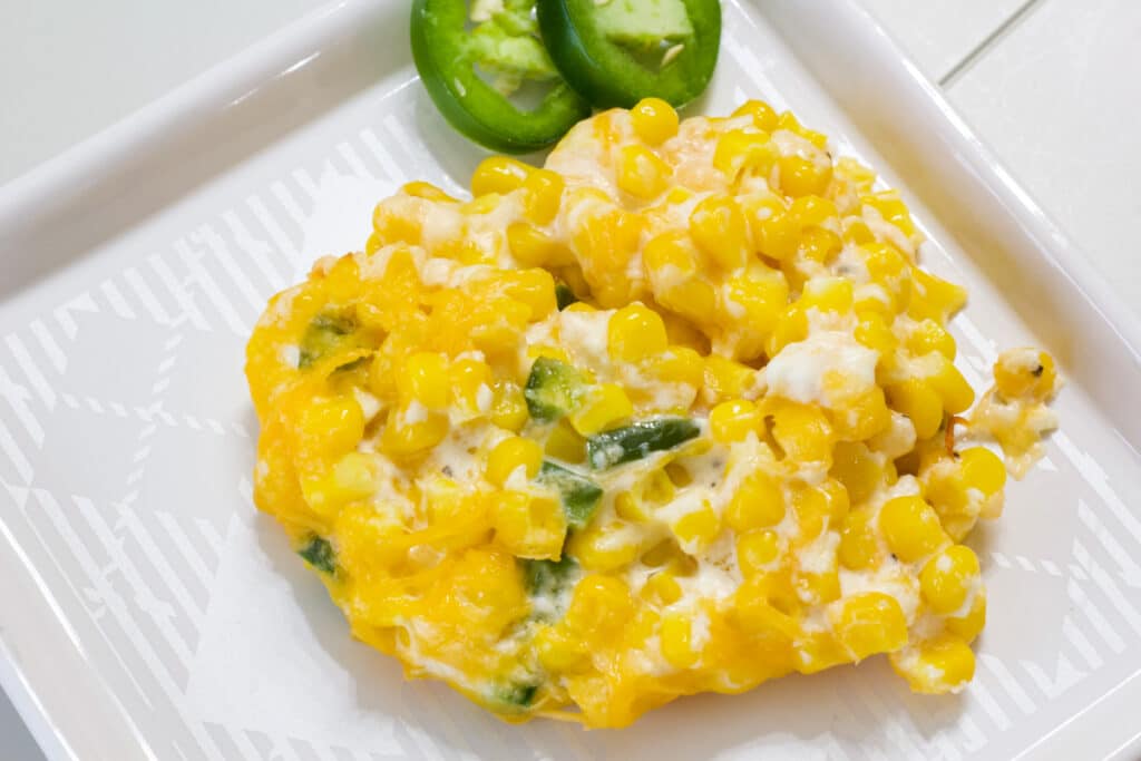 One serving of Jalapeno Cream Cheese Corn Casserole on a white plate.