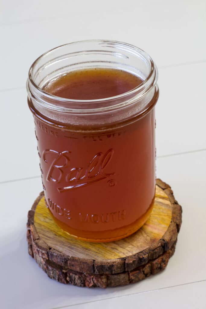 Close up of a mason jar full of Homemade Toffee Nut Syrup, there is not a lid on the jar.