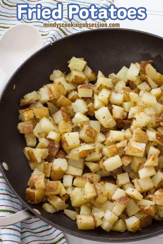 The frying pan with cooked fried potatoes in it, the recipe title is at the top in text.