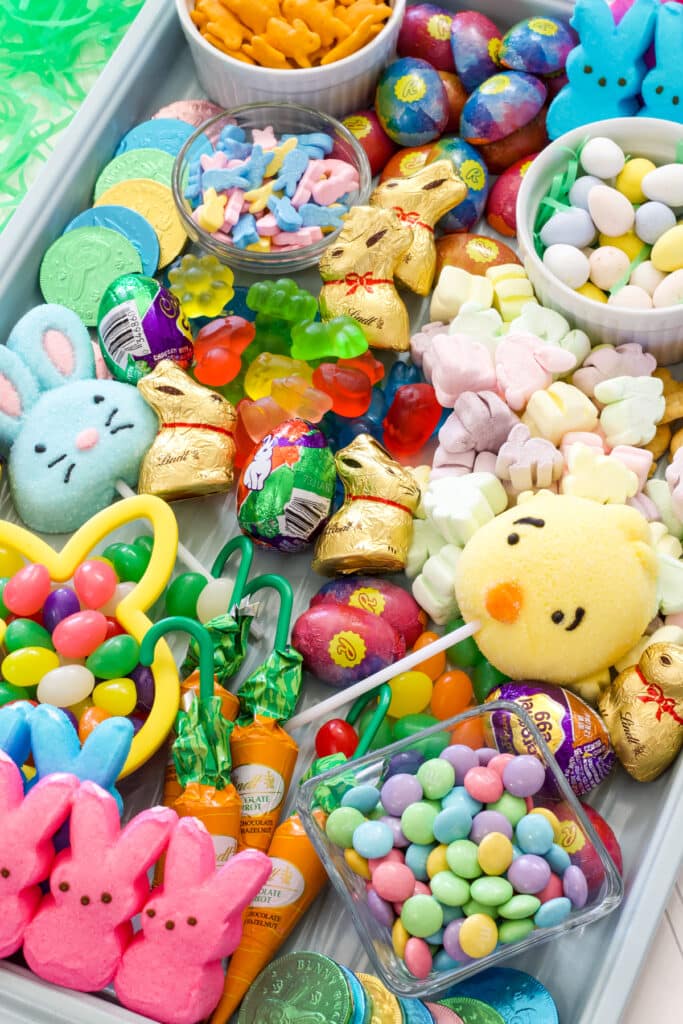 The tray with many kind of Easter candies that are pastel in color, some are shaped like bunnies.