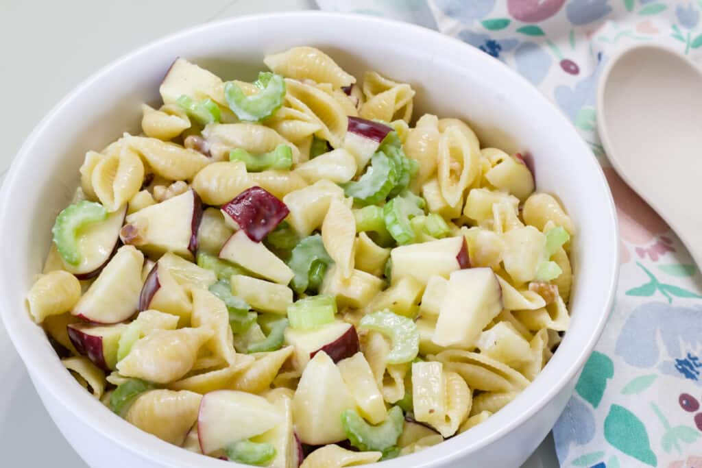 A white bowl with the entire batch of Waldorf Pasta Salad with Pineapple.