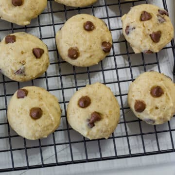 Many baked cookies on a black wire rack.