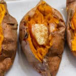 Close up overhead view of a cooked sweet potato and parts of one are visible on each side of it.