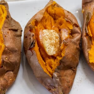 Close up overhead view of a cooked sweet potato and parts of one are visible on each side of it.