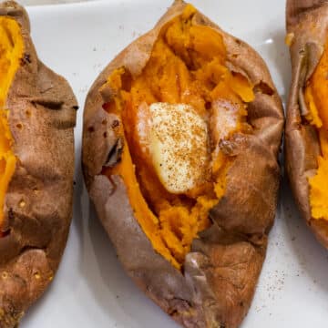 Close up overhead view of a cooked sweet potato and parts of one are visible on each side of it.