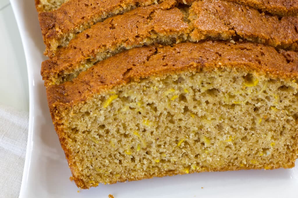 Very close up of a cut piece of moist Yellow Summer Squash Bread so the inside can be seen.