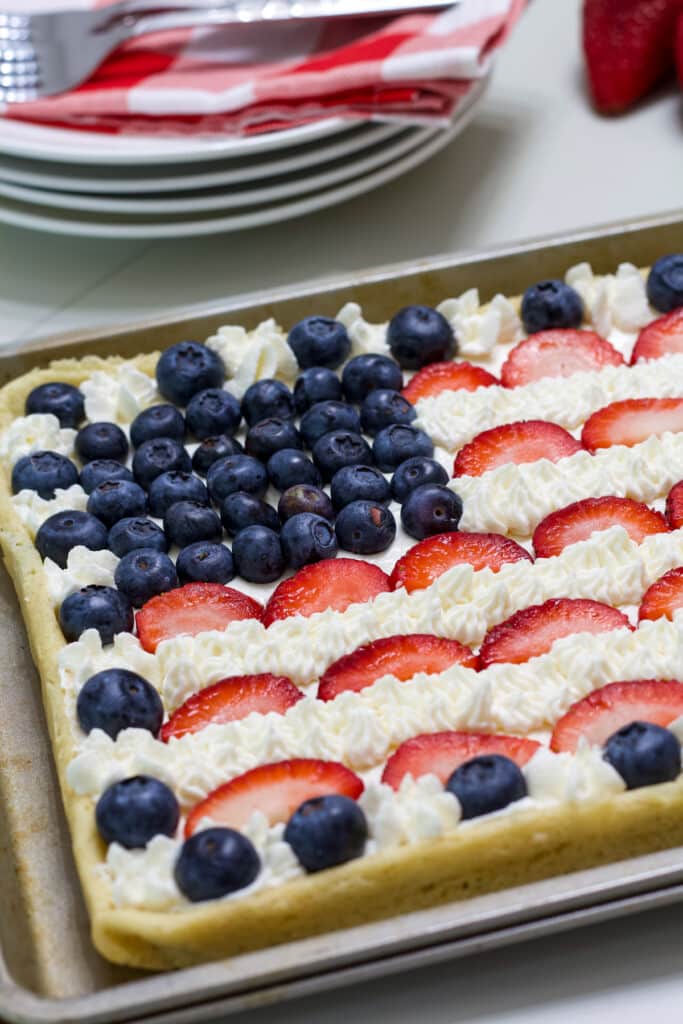 The left half of the fruit pizza is visible, the blueberries are in focus.