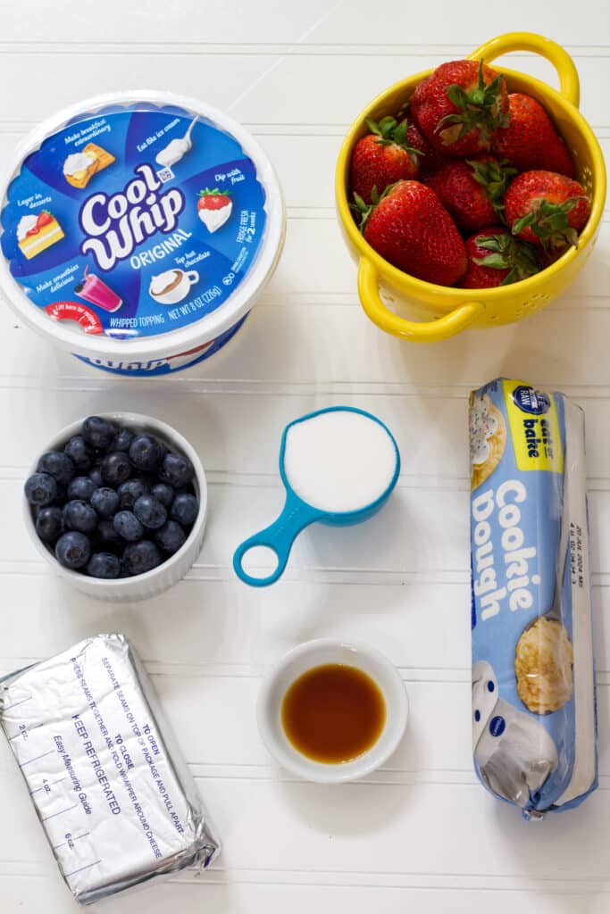 The sugar cookie dough, cream cheese, whipped topping, sugar, vanilla extract, fresh blueberries and fresh strawberries needed to make the Easy July 4th Flag Patriotic Fruit Pizza Recipe.