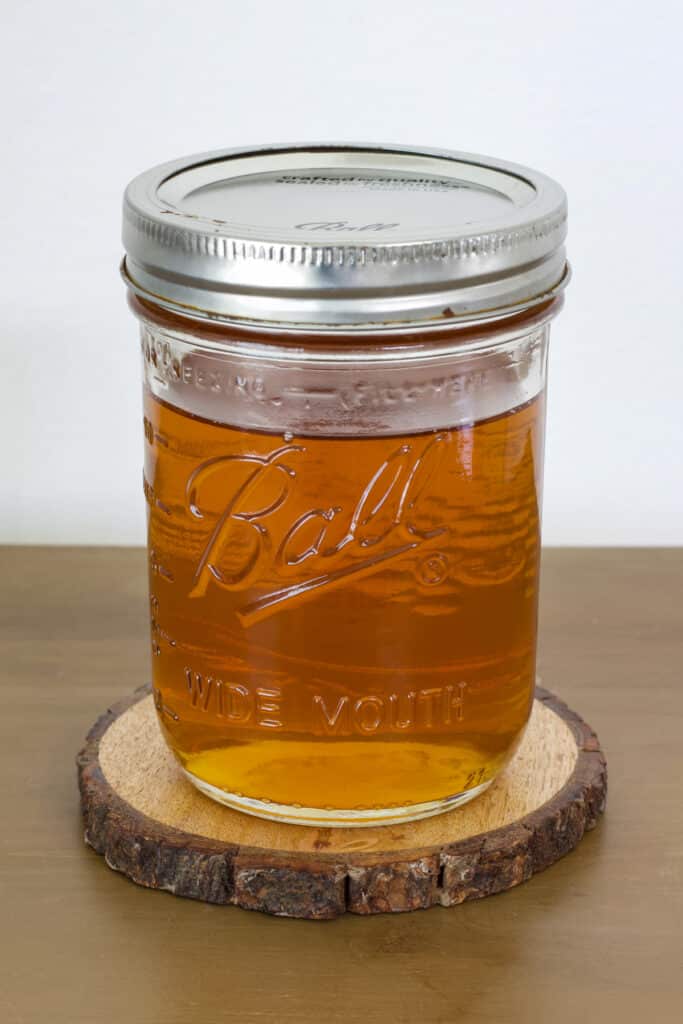A clear mason jar filled with the homemade vanilla coffee syrup.