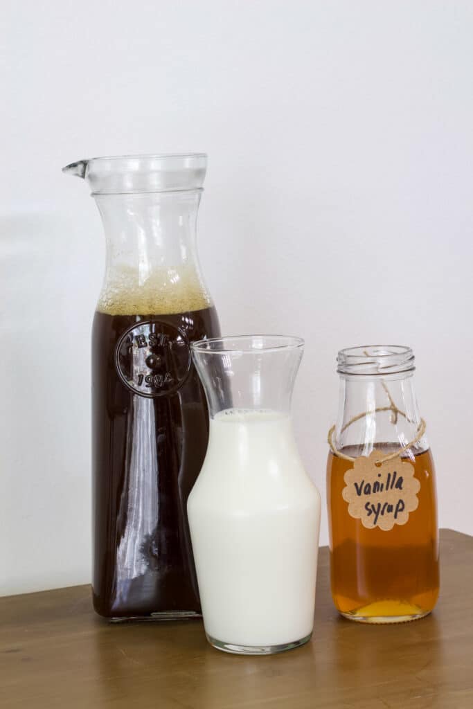Black coffee, milk and vanilla simple syrup in glass bottles, not measured out.