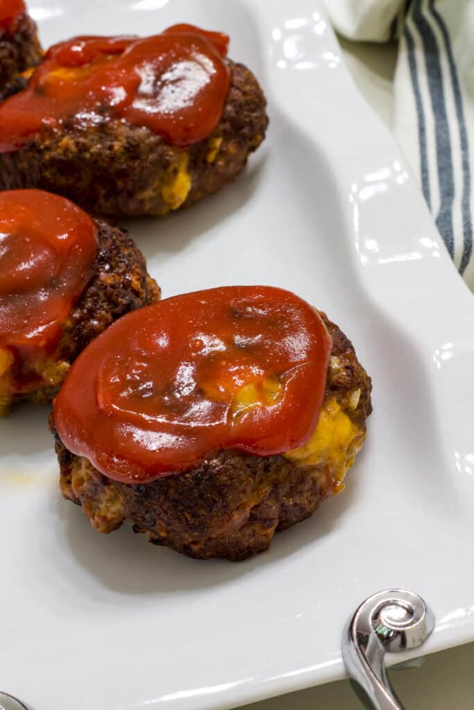 The mini meatloaves on a white serving platter.