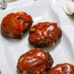 Feature image of four mini meatloaves on a white serving platter.