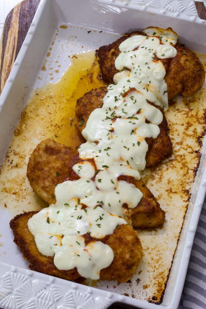 Four chicken filets in the casserole dish after it came out of the oven.