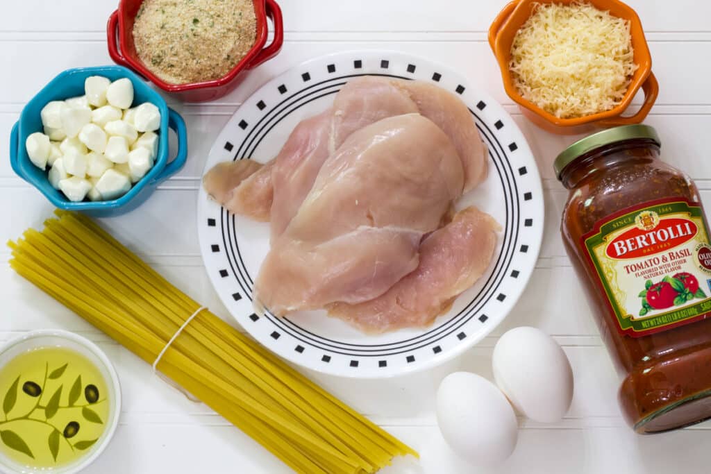 All of the eight ingredients needed to make the Best Crispy Chicken Parmesan Recipe with Jar Sauce.