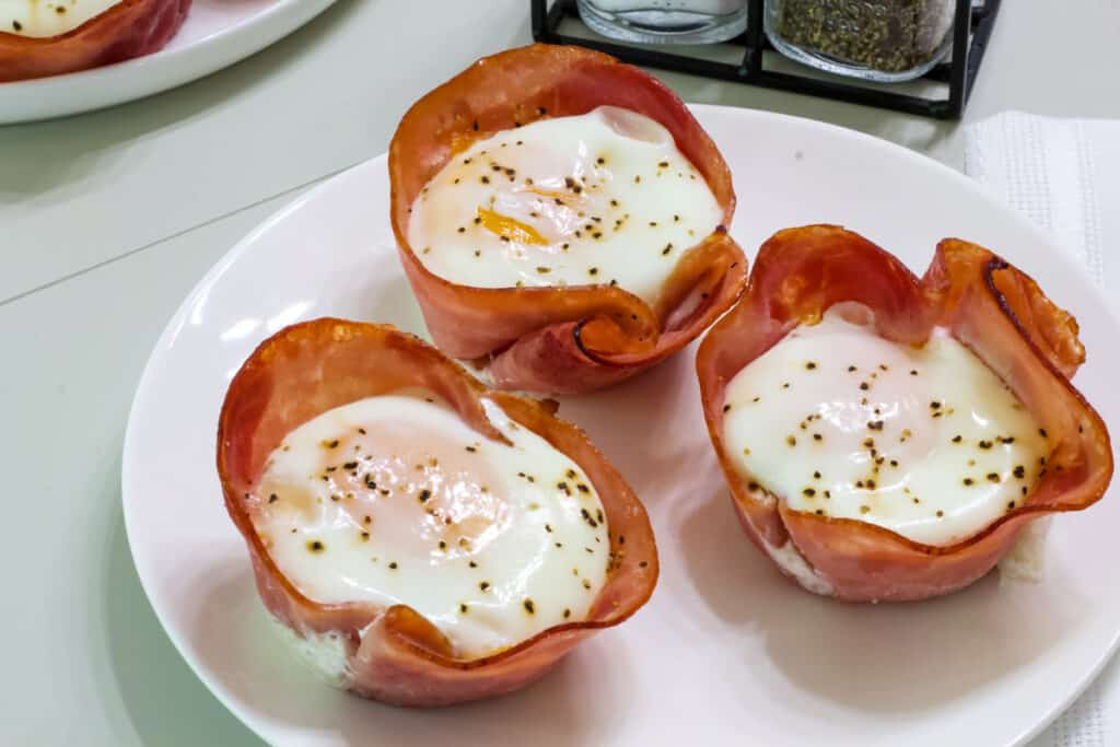 Three Baked Ham Cheese & Egg Breakfast Cups on a white plate.