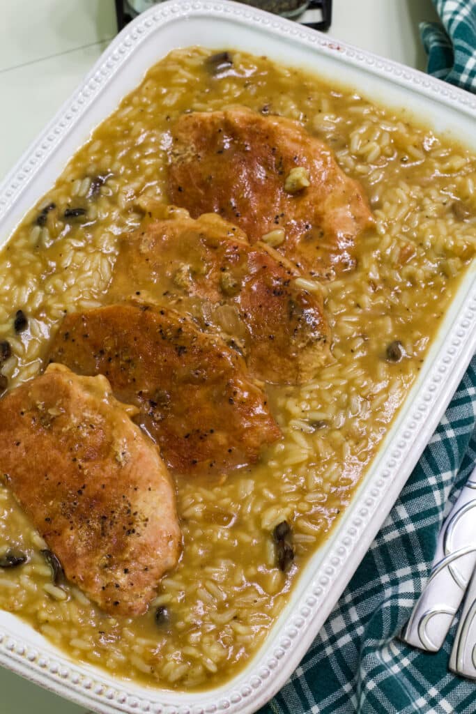 The entire dish after it has been cooked and the rice mixed in the sauce, it is in a white casserole dish.