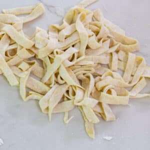 The feature image of a pile of raw egg noodles right after they were cut into strips.