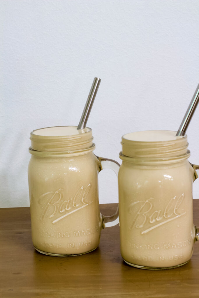 Two servings of copycat frosted coffee Ball mason jar mugs with silver straws in them.