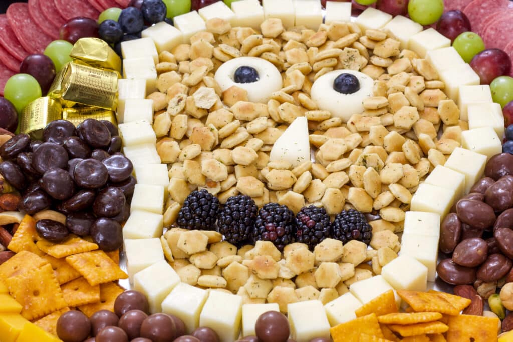 Close up of meats, cheeses, crackers, fruit and candy in the shape of a skull.