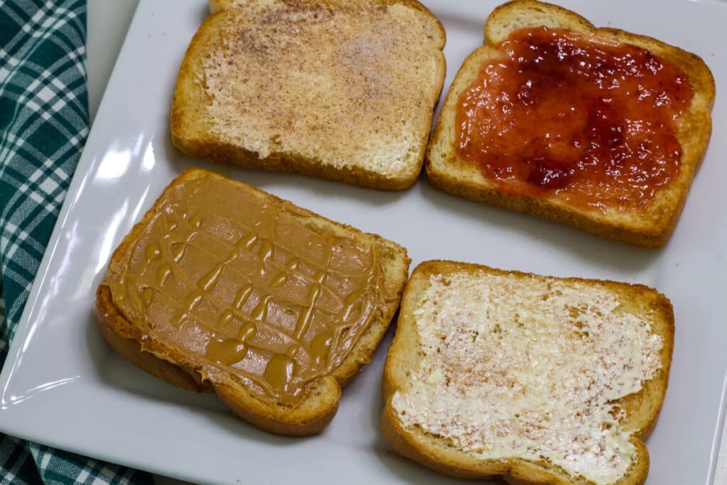 Four pieces of air fried toast with different toppings on them.