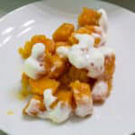 Feature image of one serving of Sweet Potatoes Topped with Marshmallows on a white plate.