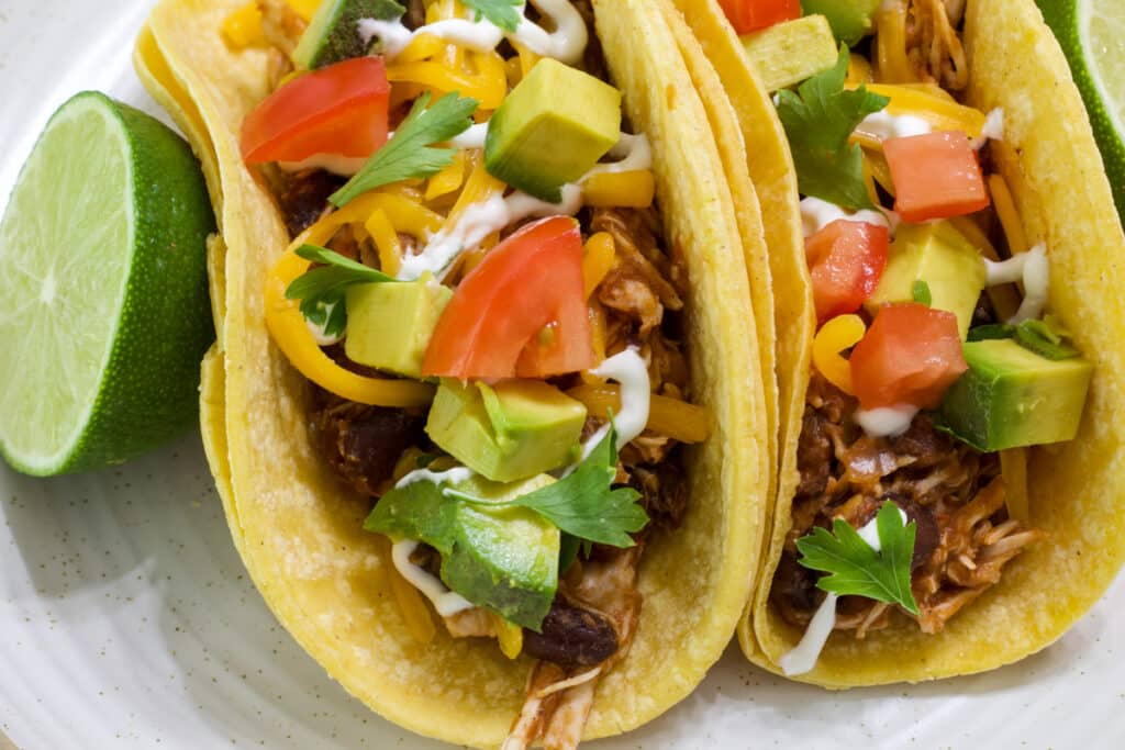 Two Mexican chicken tacos that were made using Crockpot Mexican Chicken.