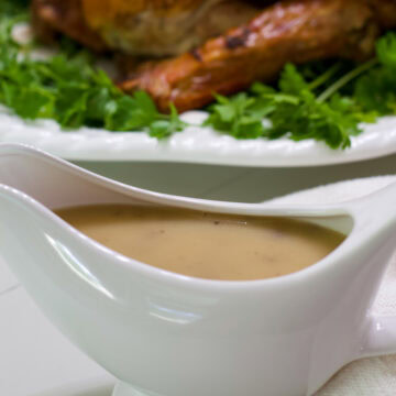 Feature image of a white gravy boat filled with homemade giblet gravy.