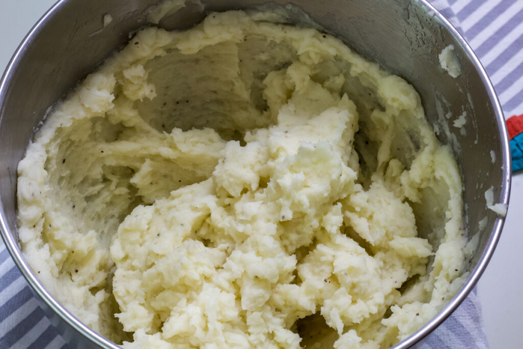 The whipped potatoes in the bowl of the stand mixer.