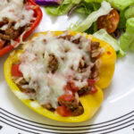Feature image close up of one baked stuffed pepper half on a plate ready to eat.