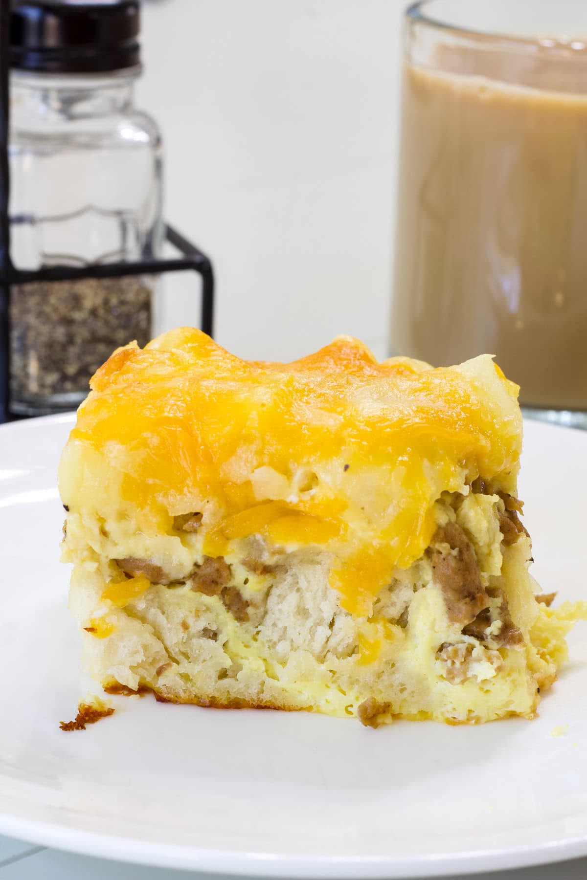 Side view of one serving of Sausage Biscuits Breakfast Casserole on a white plate.