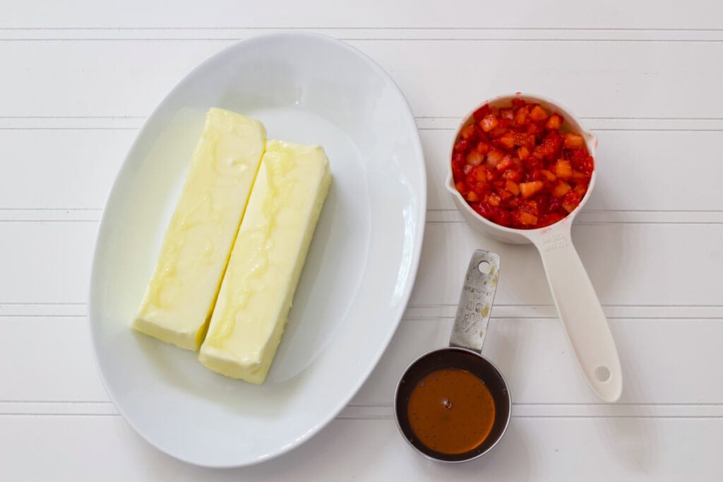 Two sticks of butter, chopped strawberries and honey measured out to make the Whipped Strawberry Honey Butter recipe.