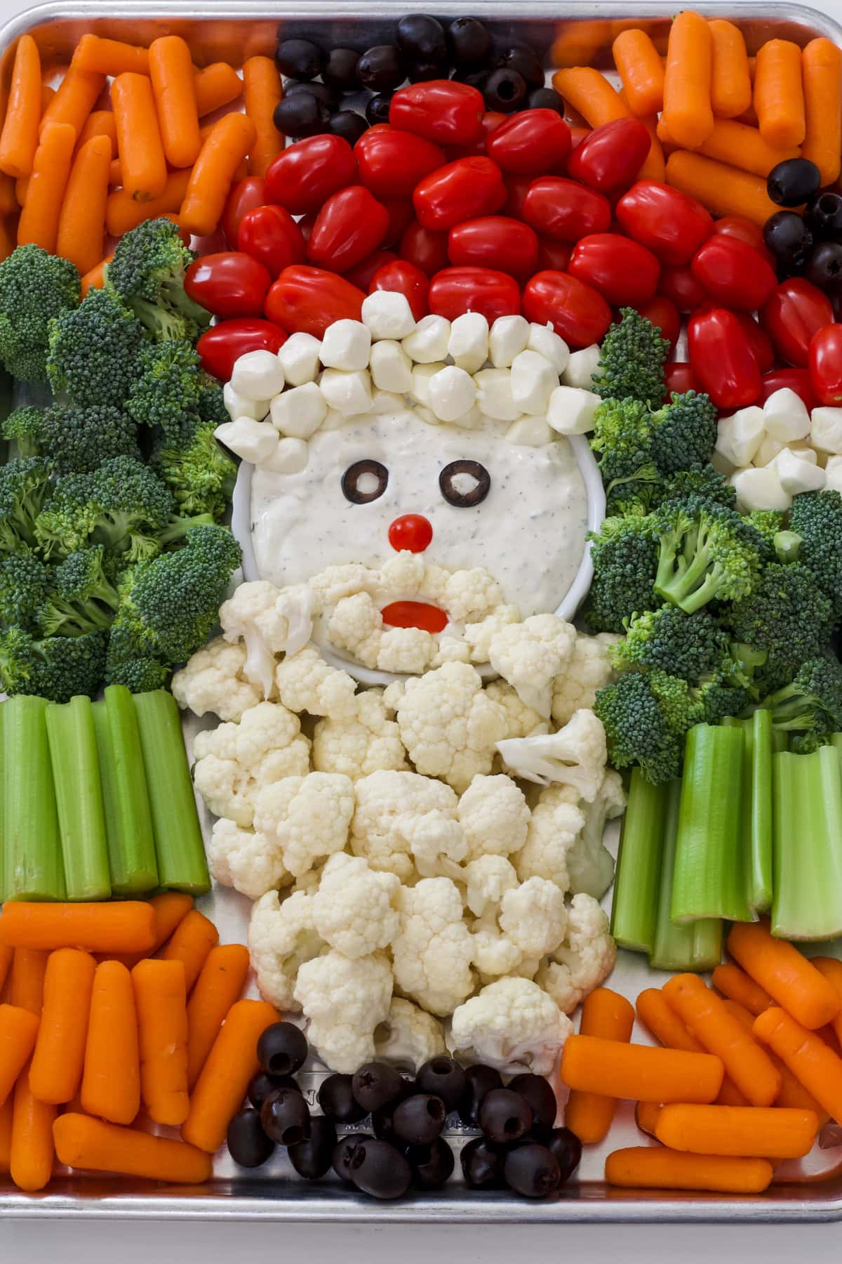 Overhead view of the entire vegetable platter with cauliflower florets for Santa's beard and cherry tomatoes for his hat.