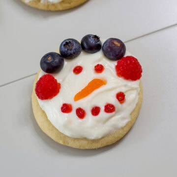 Feature image of one Snowman Fruit Cookie Pizza on the table.