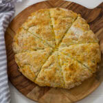 Feature image of the entire batch of baked scones on a wooden cutting board.