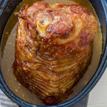 Feature image that's an overhead view of the baked ham and juices in the roasting pan.