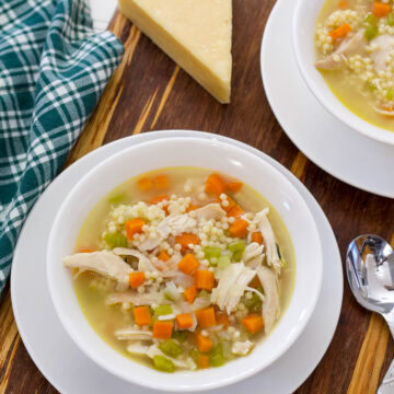 Feature image of a bowl of Chicken Pastina Soup with a spoon next to it.