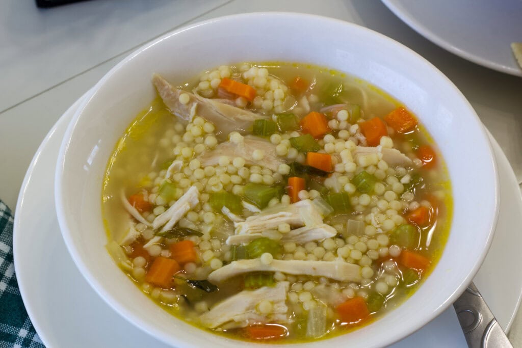 Close up overhead view of one bowl of chicken pastina soup.