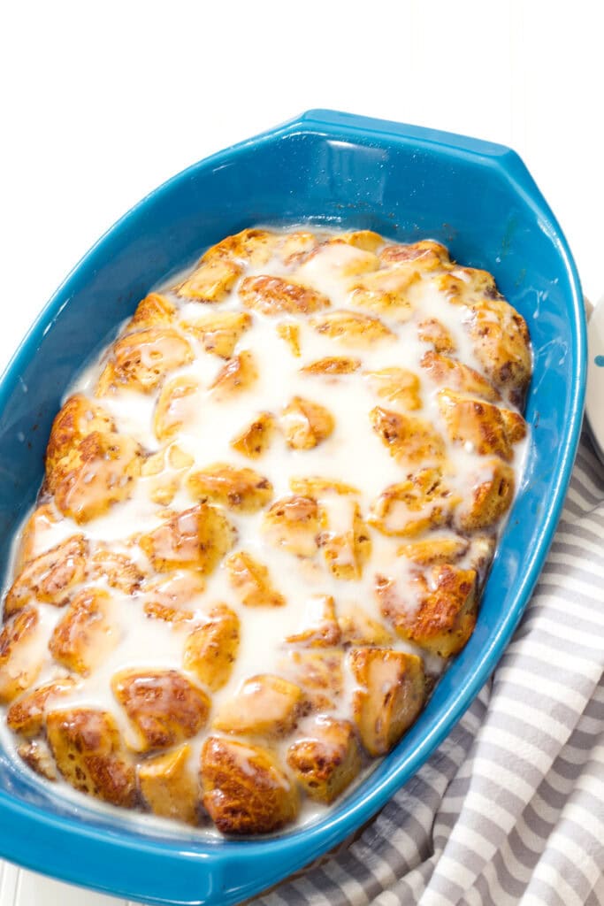 The entire uncut cinnamon roll breakfast casserole in a blue casserole dish.