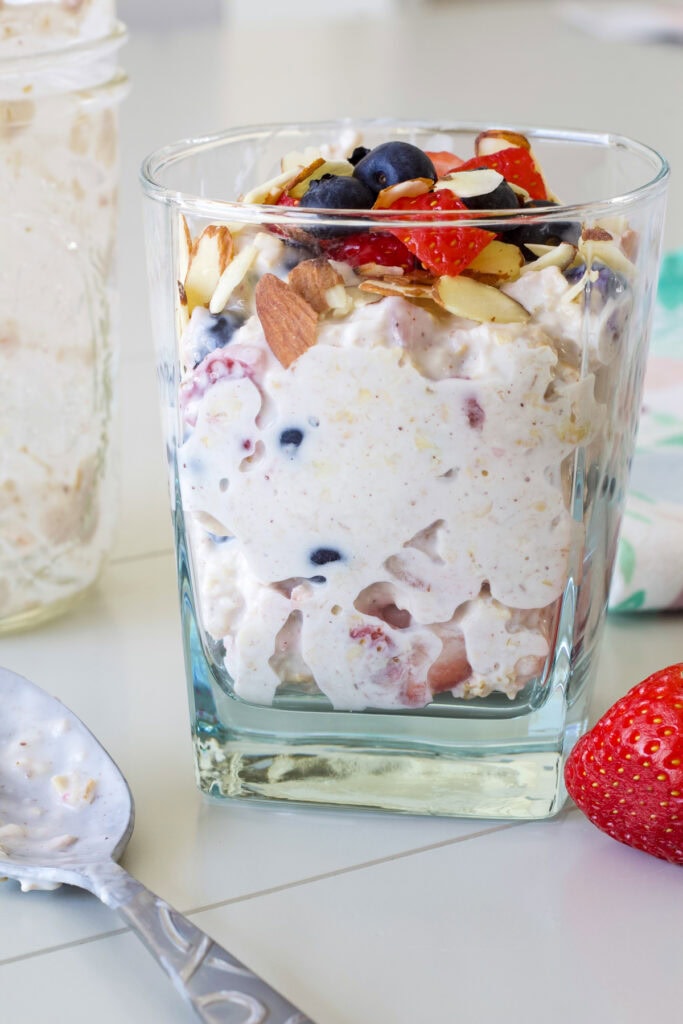 One serving of berry overnight oats in a glass so the oats are visible.