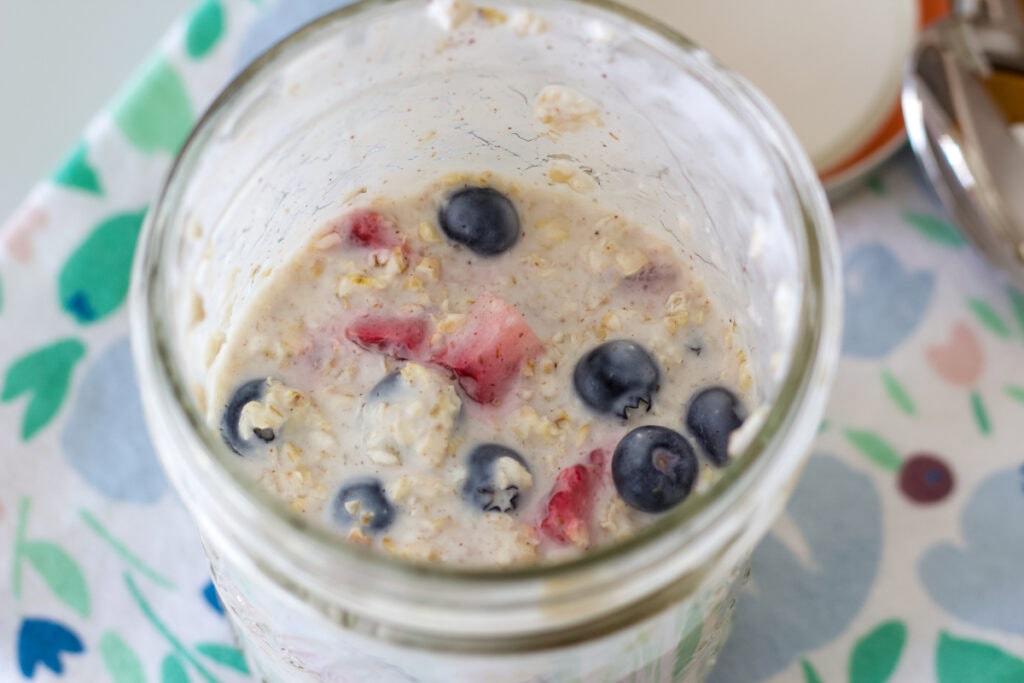 Overhead shot of oats in a mason jar after they've been in the fridge overnight. There is no topping.