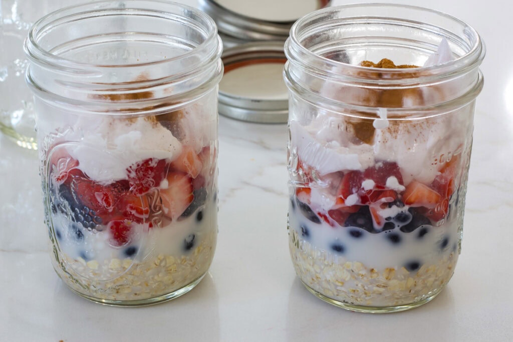 Two mason jars with the ingredients layered in the jar before they were mixed.