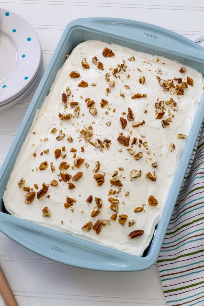 The finished uncut carrot cake in a turquoise colored cake pan.