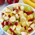 Feature image of a white serving bowl filled with fruit salad.