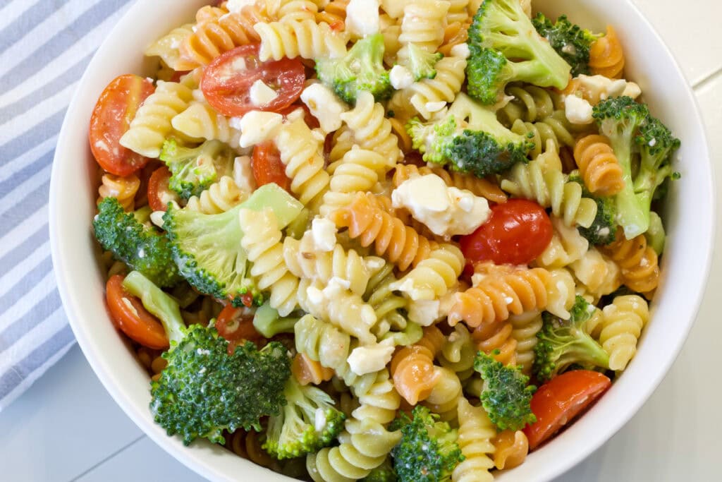 Close up overhead shot of the Rainbow Pasta Salad in a white serving bowl.