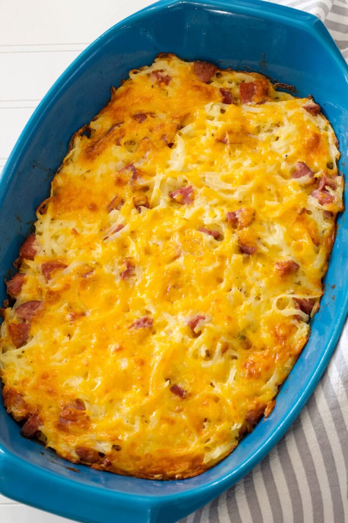 The entire baked Smoked Sausage Hash Brown Casserole in a blue casserole dish.