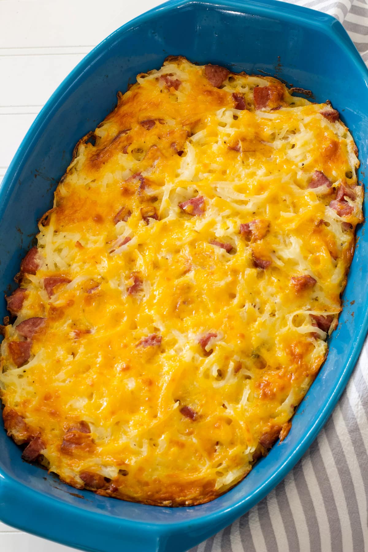 The entire baked Smoked Sausage Hash Brown Casserole in a blue casserole dish.